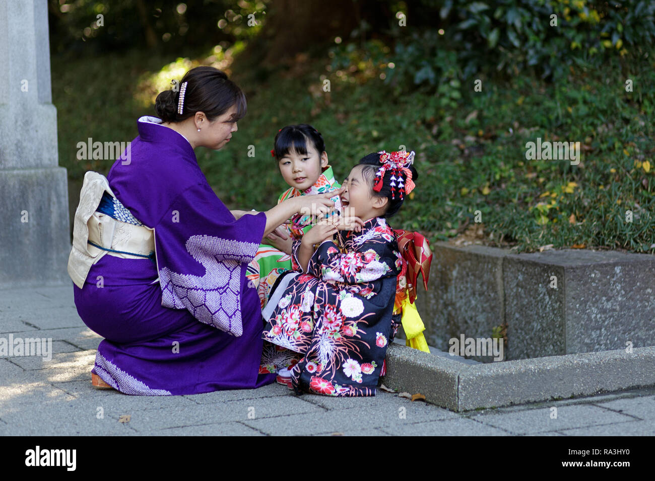 Mother and girl wearing a festive kimono playing at the Shichi-go-san or Seven-Five-Three festival at Meiji Shrine, Yoyogi park, Tokyo, Japan Stock Photo