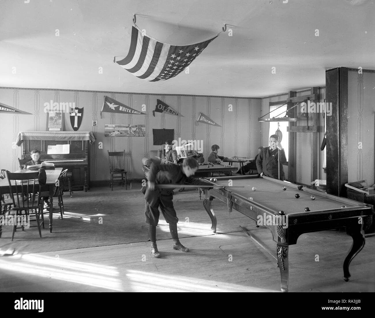 Early 1900s men playing billards in pool room ca. early 1900s Stock Photo