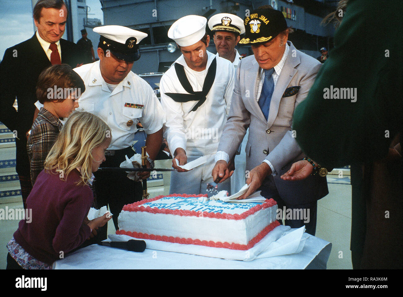 1979 - After the Bob Hope show aboard the amphibious assault ship USS IWO JIMA (LPH-2), Bob Hope is honored with a cake for his 76th birthday. Stock Photo