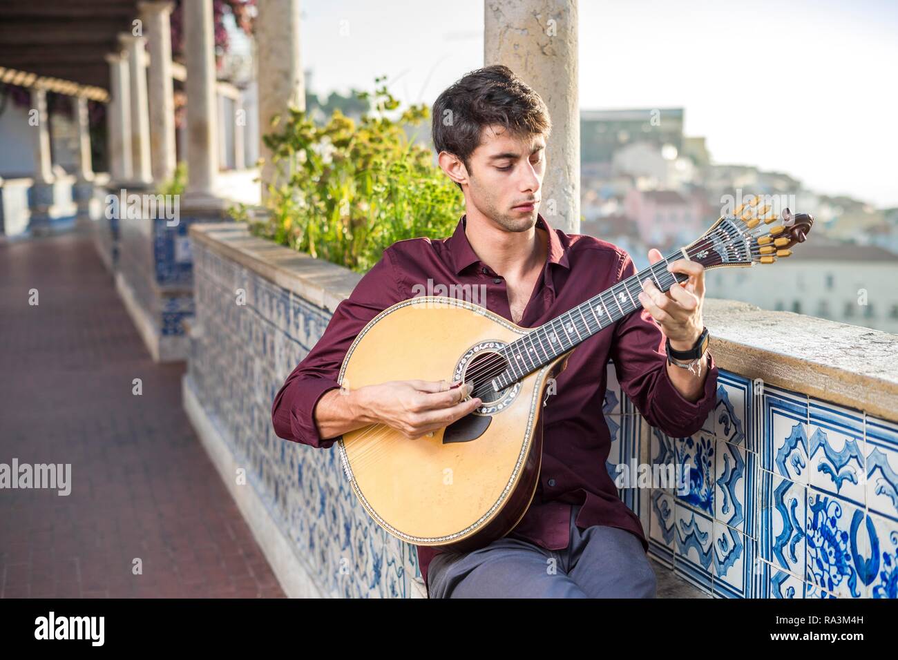 Fado musician playing on unique portuguese guitar in Alfama, Lisbon, Portugal Stock Photo