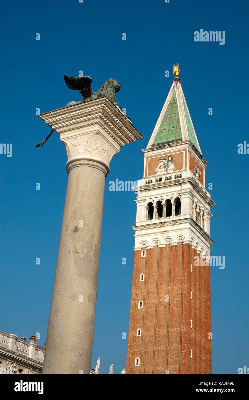 Winged lion on granite column with church tower of Basilica di San Marco, Campanile di San Marco, Piazza San Marco, Venice Stock Photo