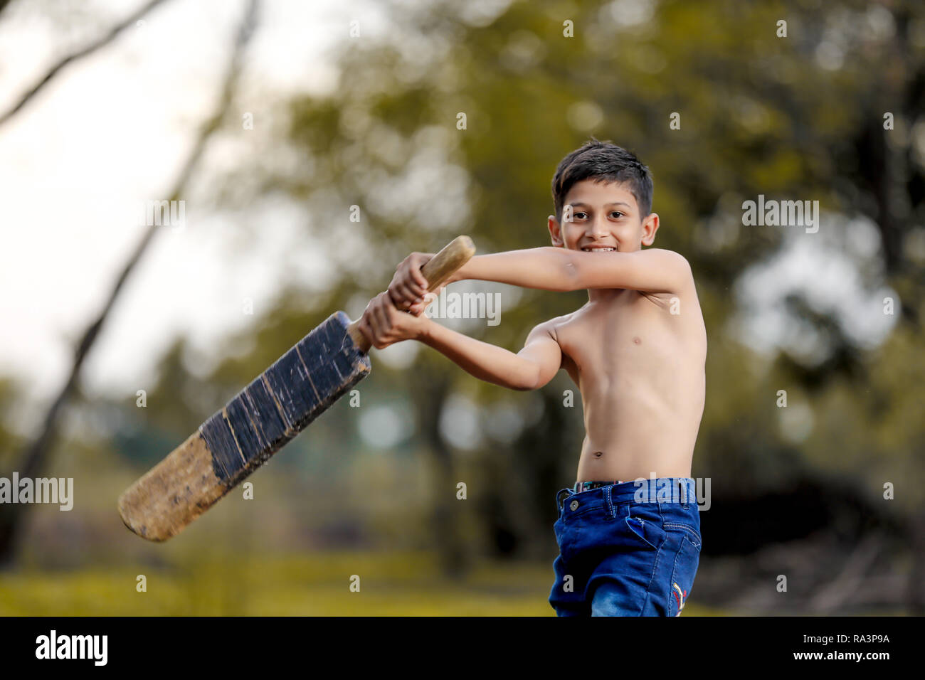 Rural Indian Child Playing Cricket Stock Photo