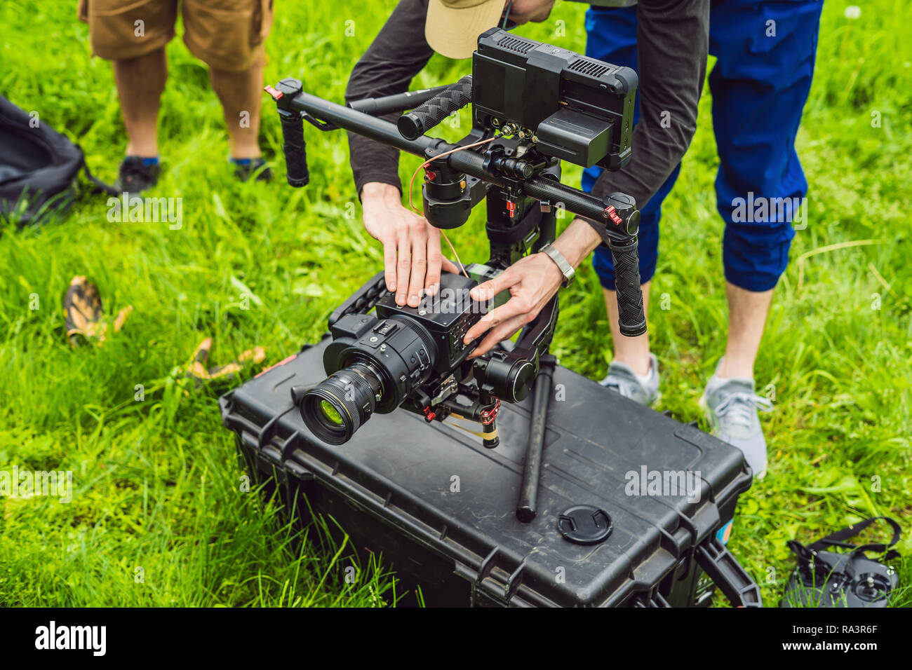 Cameraman setting up heavy duty professional 3axis gimbal stabilizer for cinema camera Stock