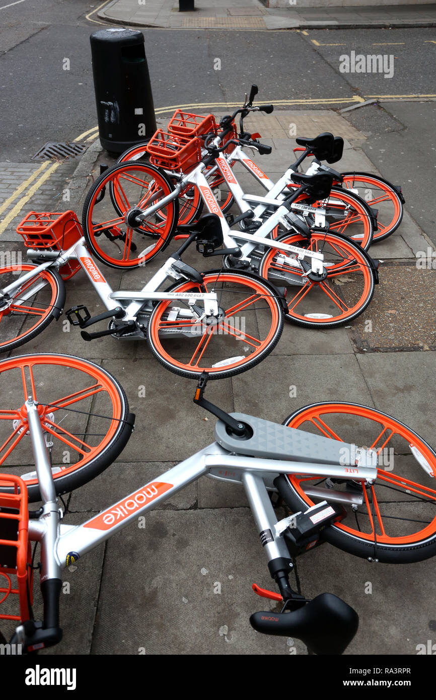 A selection of Mobike's pictured knocked over on the floor in London, UK. Stock Photo