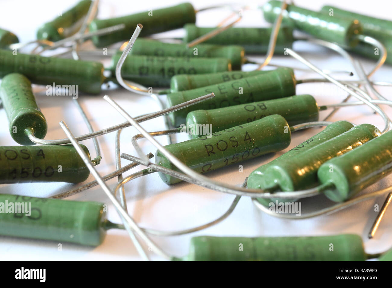 A heap of big ceramic green power resistors with 1.5 KOhm resistance and 5 Watt power dissipation, with axial horizontal through hole mount, with pins Stock Photo