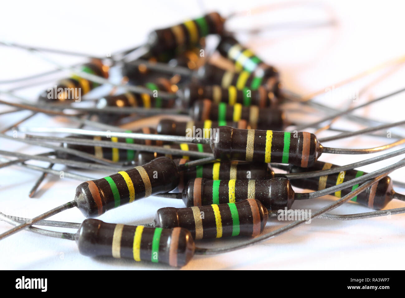 A heap of multicolored brown resistors with 150 KOhm resistance and 1 Watt power dissipation, with axial horizontal through hole mount, with pins Stock Photo