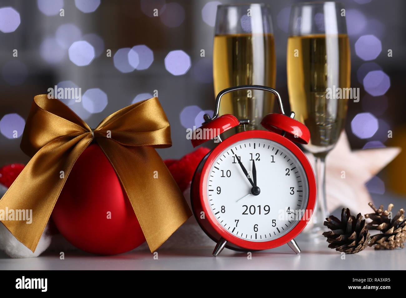 Red alarm clock and champagne goblet at office table Stock Photo