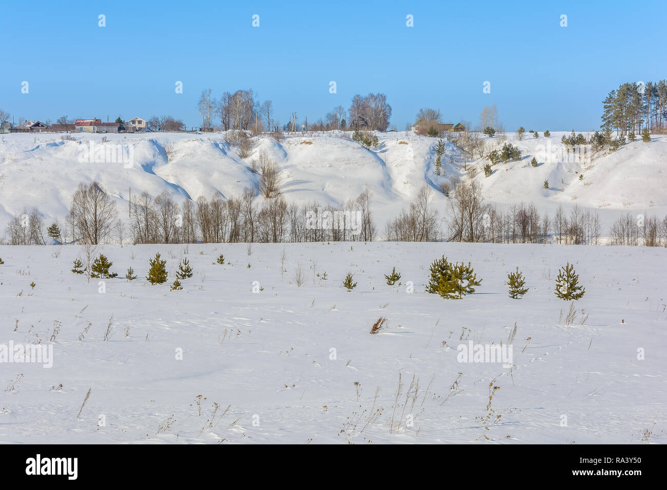 The snowy hills around the fields and forests in winter Stock Photo