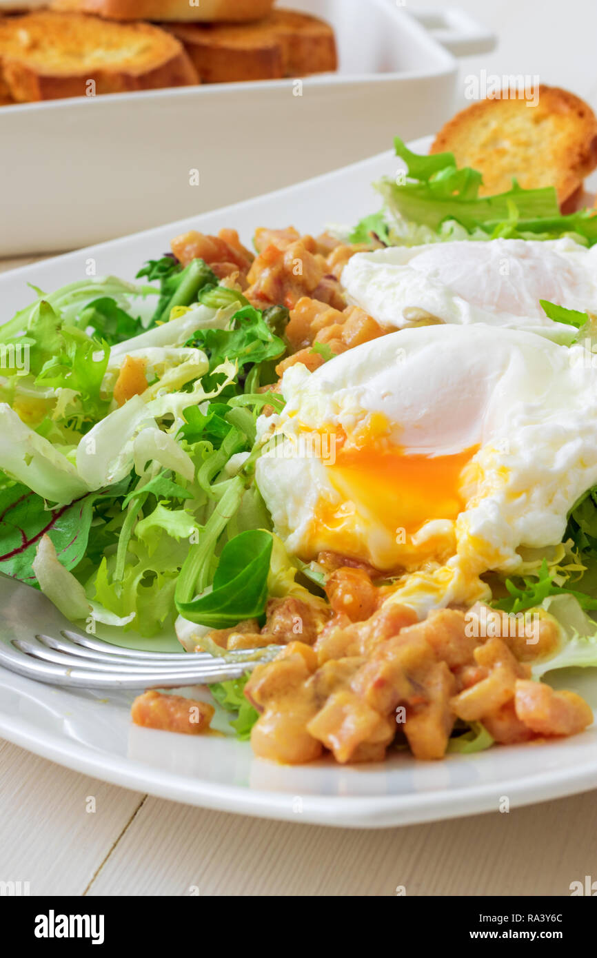 Classic French salad, great salad Lyonnaise. Dish with green leaves of