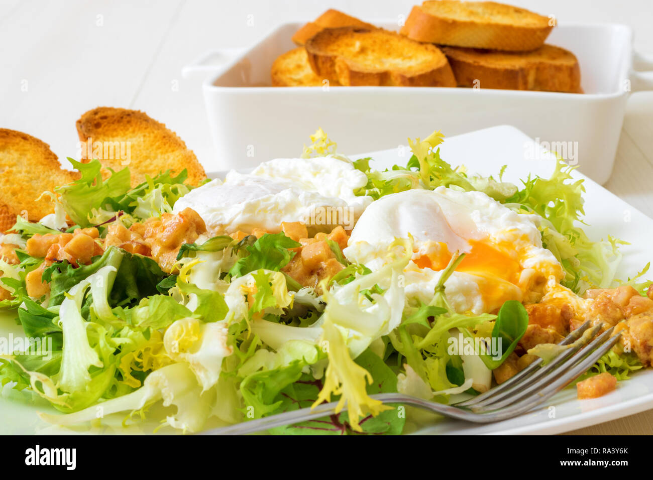 Classic French salad, great salad Lyonnaise. Dish with green leaves of