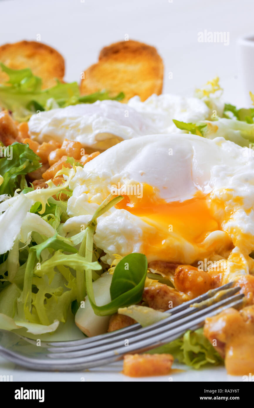 Classic French salad, great salad Lyonnaise. Dish with green leaves of