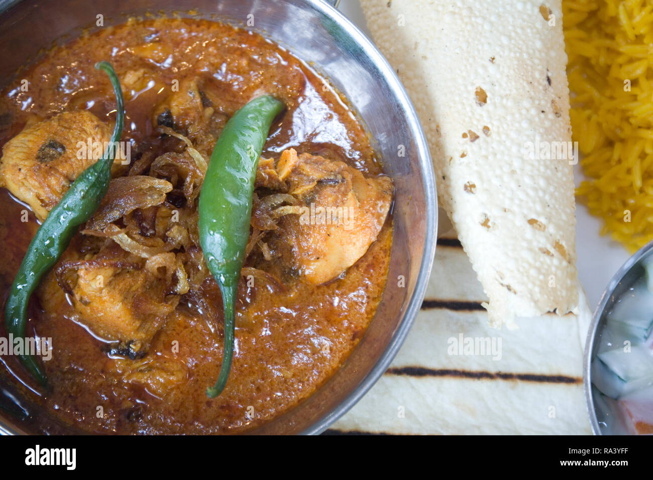 Garlic chilli chicken. Marinaded chicken meat curry with whole chilli garnish rice, poppadom and