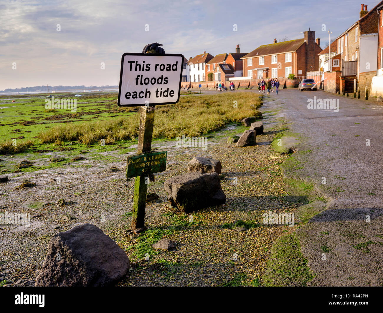 A sign saying 'This road floods each tide' on Shore Road Bosham Harbour near Chichester, West Sussex UK. Stock Photo
