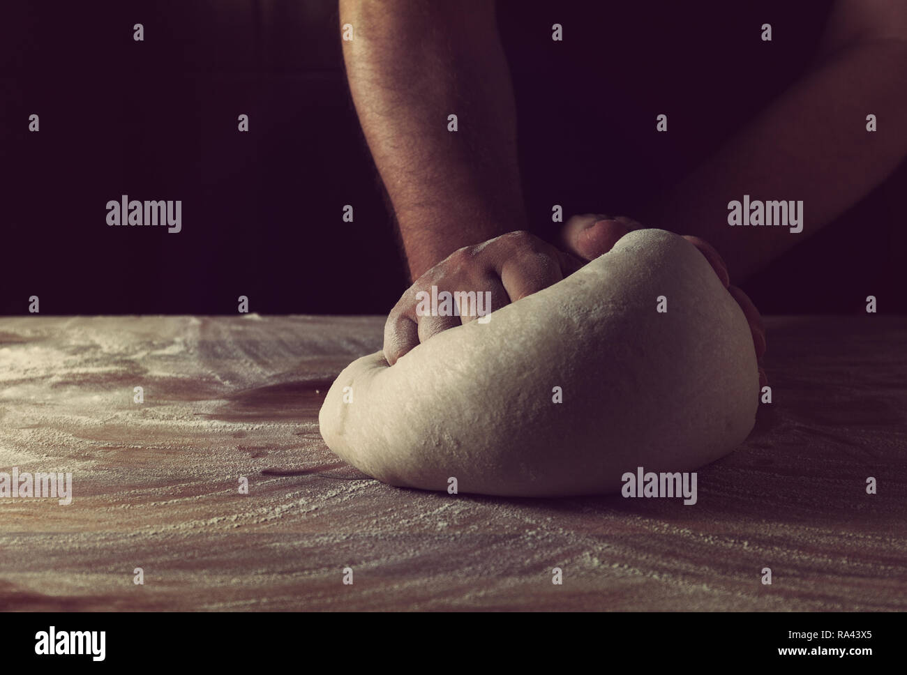 Chief baker preparing dough for bread in a bakery. Kitchen professional. Stock Photo