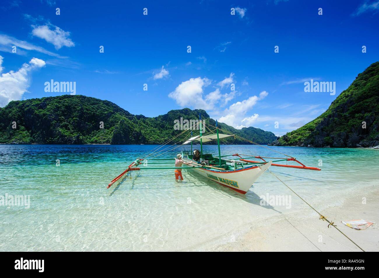 Outrigger boat in the crystal clear water in the Bacuit archipelago, Palawan, Philippines Stock Photo