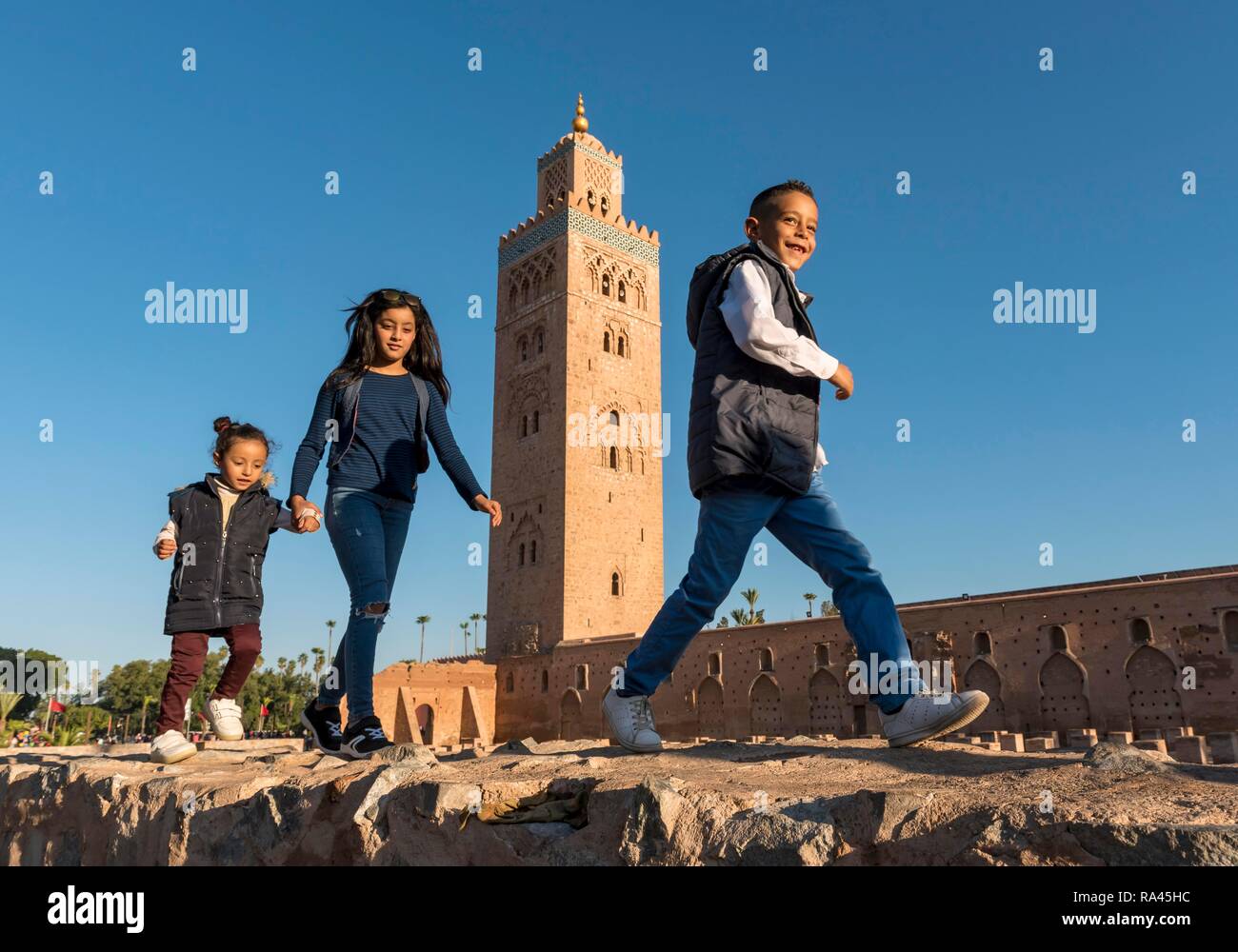 Marrocan children play outside Koutoubia Mosque, Marrakech, Morocco Stock Photo