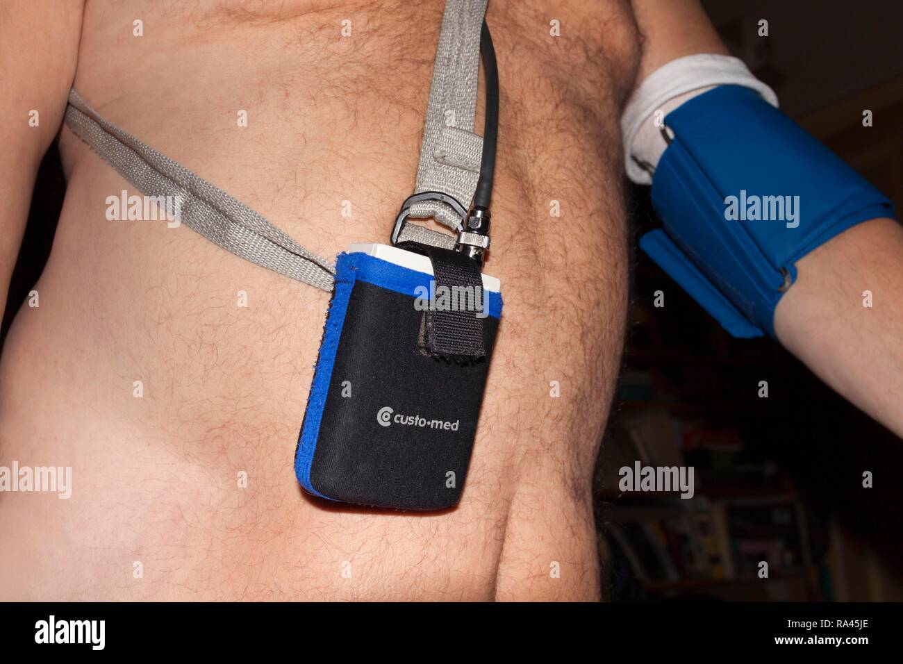 Man with naked upper body wears a long-term stress blood pressure monitor, Berlin, Germany Stock Photo