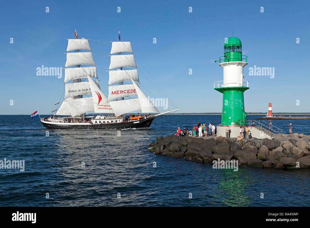 Lighthouse with sailing boat Mercedes at back, Hanse Sail, harbour entrance, port entrance Warnemünde Stock Photo