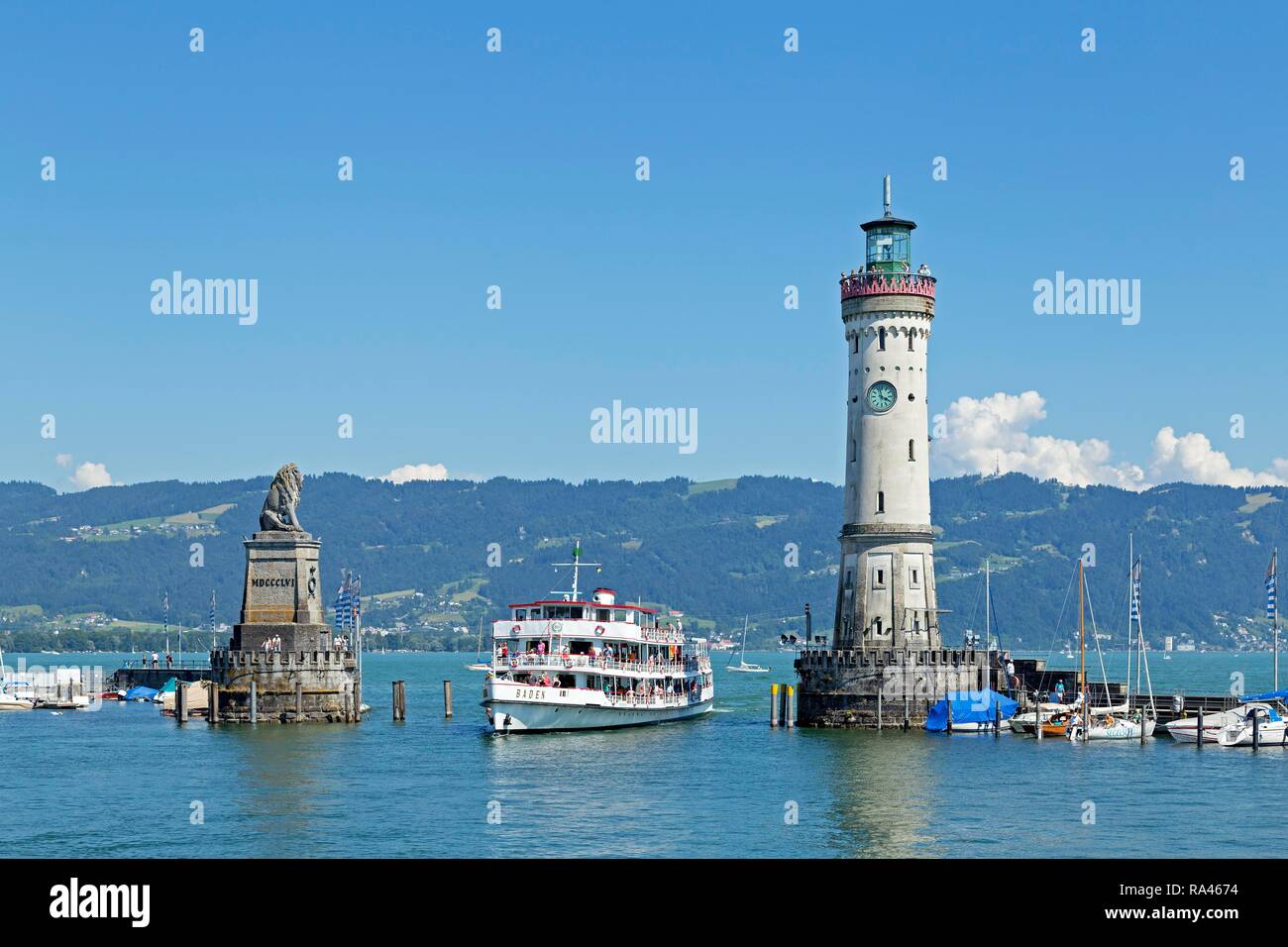 Passenger ship in port entrance with lighthouse in the harbor, Lindau, Lake Constance, Bavaria, Germany Stock Photo