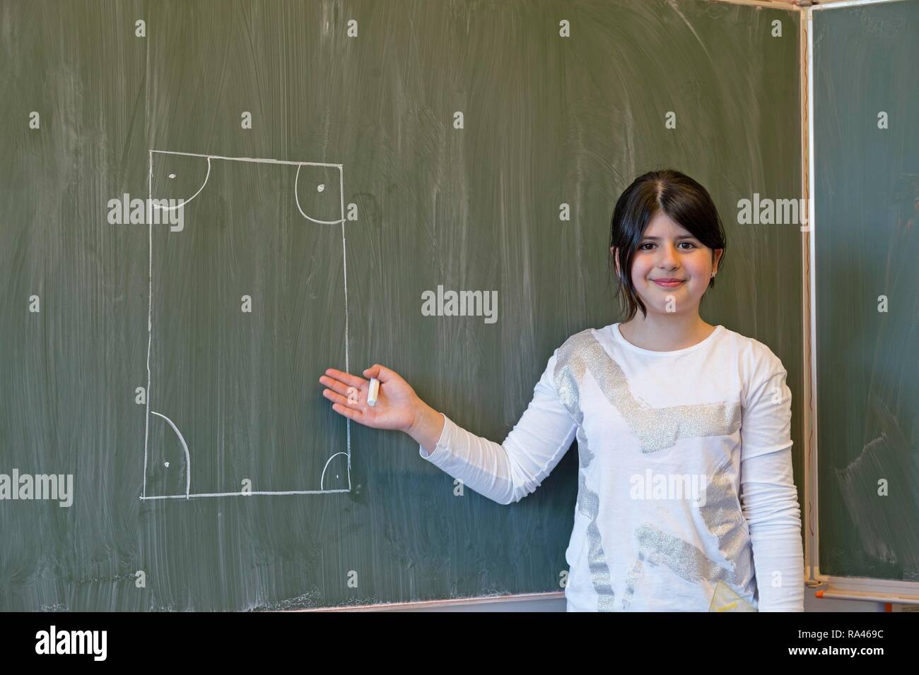 Girl at blackboard, drawn rectangle, elementary school, Germany Stock Photo