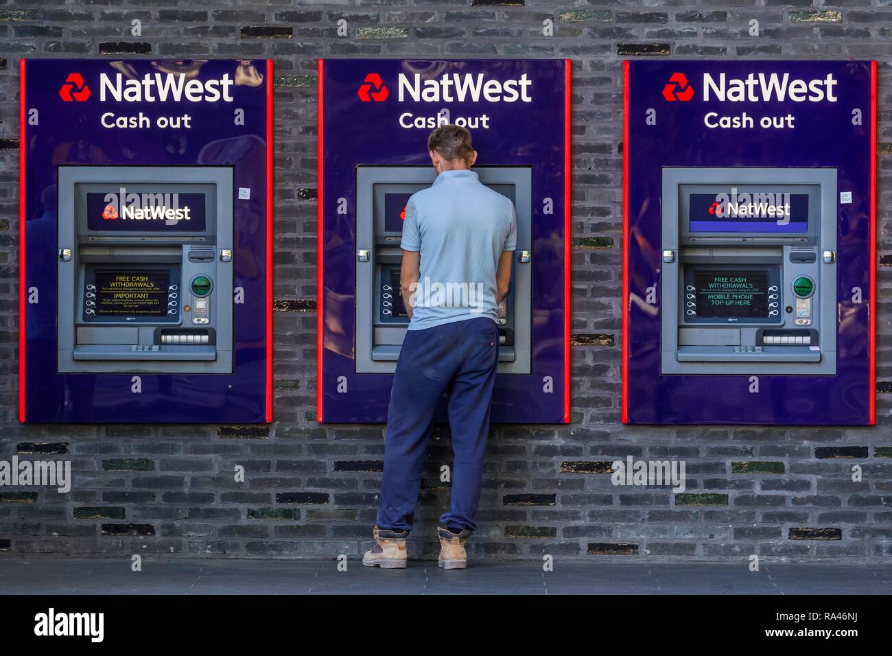 Man at the cash dispenser of NatWest Bank, London, Great Britain Stock Photo