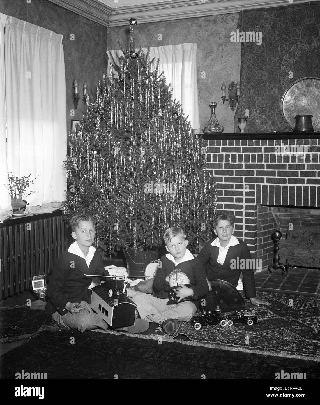 These happy boys grouped about their Christmas tree are Jr