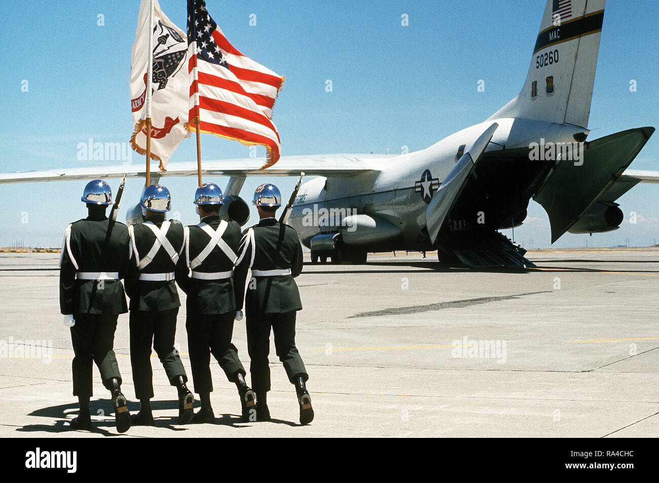 1977 - An Army color guard marches out to meet a C-141 Starlifter aircraft carrying the caskets of three U.S. Army soldiers who were killed in a helicopter crash in Korea on July 14, 1977. Stock Photo
