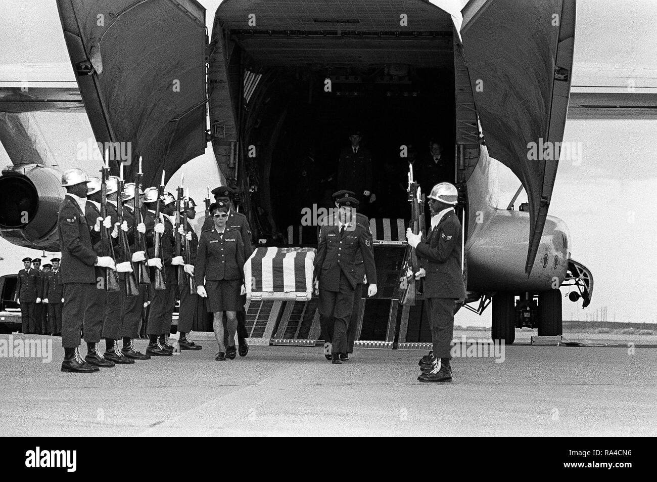 1977 - An Air Force honor guard stands at attention while the casket of an MIA from North Vietnam is removed from a C-141 Starlifter aircraft. Stock Photo