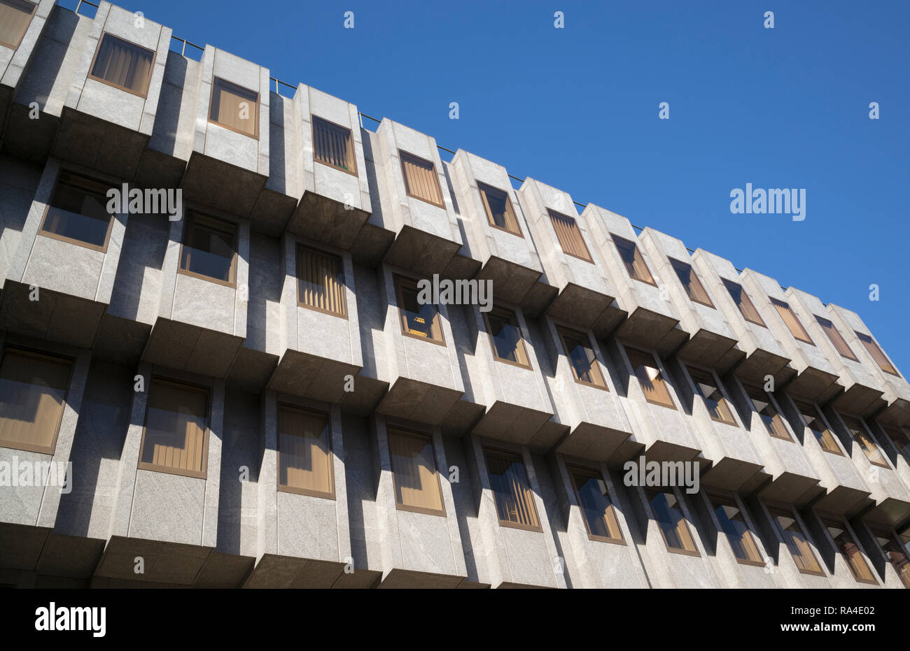 Upper floors and tinted windows of low-rise concrete office block in ...