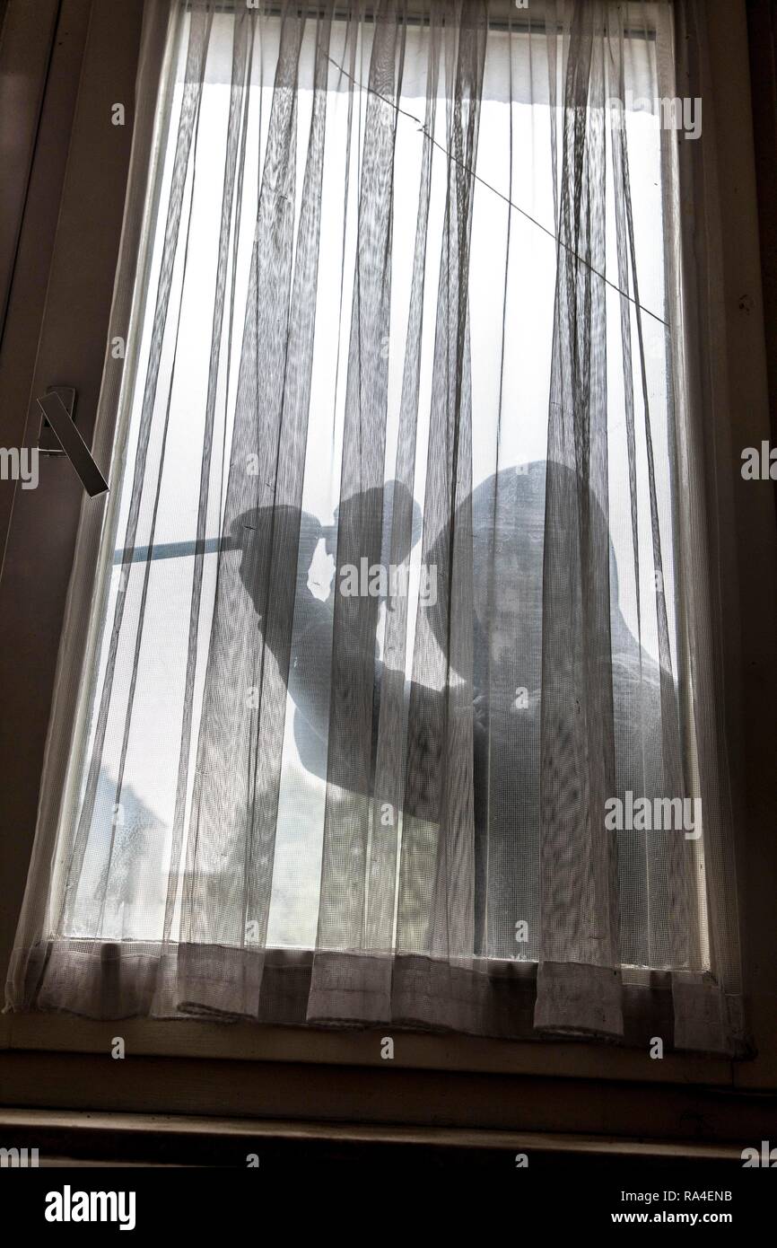 Symbol picture apartment burglary, perpetrator tries to break into an apartment, picks up a window with a tool Stock Photo