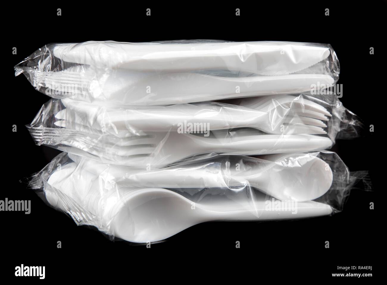 Large pack of plastic cutlery, disposable cutlery, knives, forks, spoons, plastic waste Stock Photo