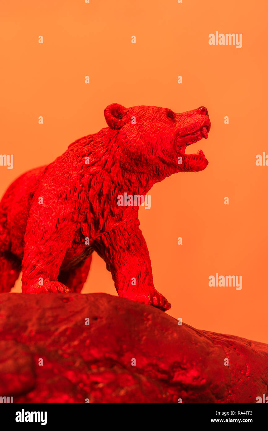 Toy bear stands on rock against plain background, all colour lit. For bear market, market bears, Stock Market bearish,being bearish, market crash 2020 Stock Photo