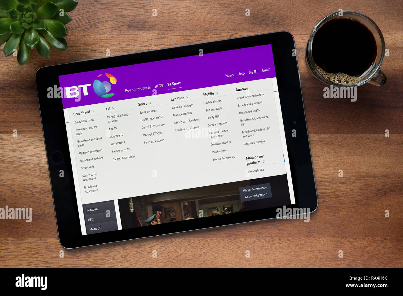 The website of BT (British Telecom) is seen on an iPad tablet, on a wooden table along with an espresso coffee and a house plant (Editorial use only). Stock Photo