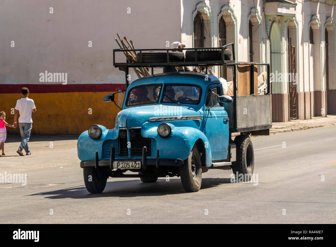 classic old blue American truck driving down a havana street in Cuba