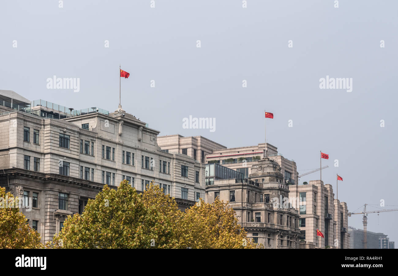 Historic buildings with chinese flags on The Bund in Shanghai Stock Photo