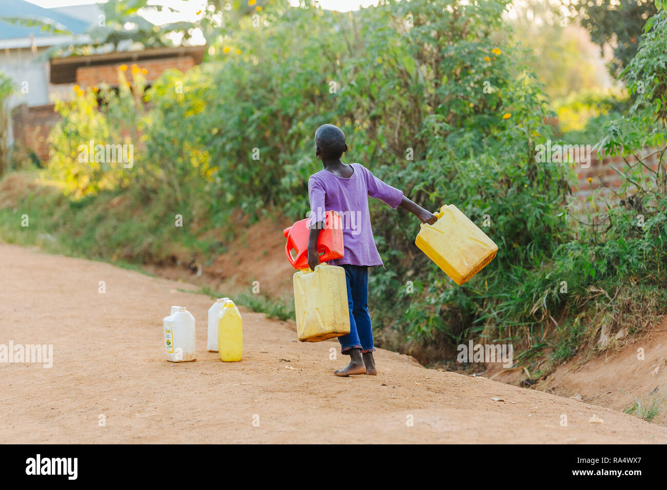 Child carrying water in Uganda, Africa Stock Photo Alamy