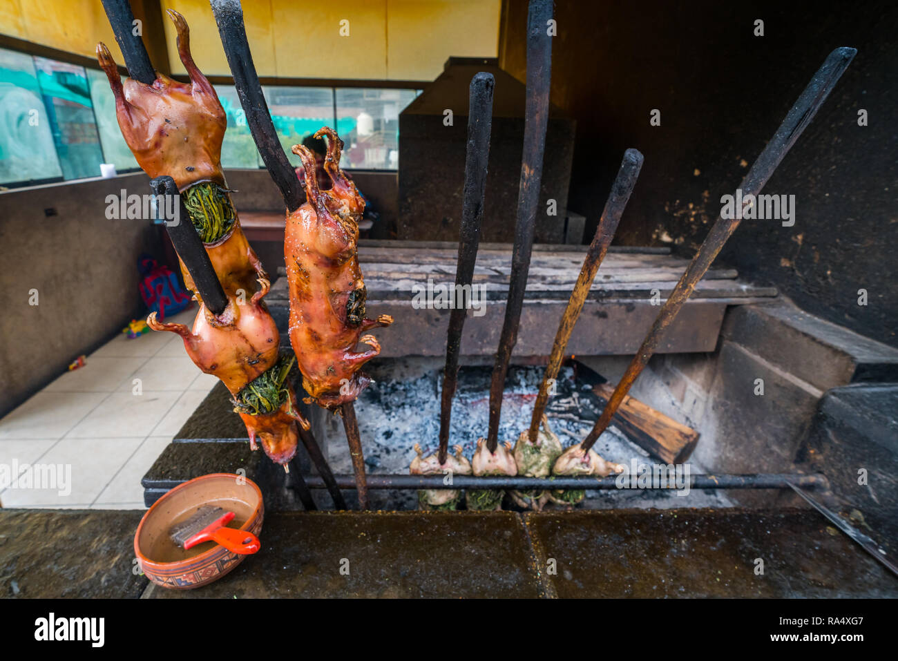 Traditional Peruvian roasted guinea pigs on the sticks, prepared on grill. Viewed in close-up Stock Photo
