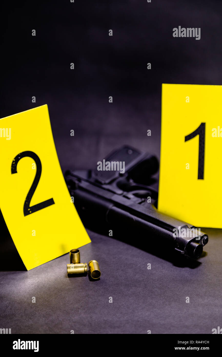 Bullets and gun next to markers at crime scene Stock Photo - Alamy