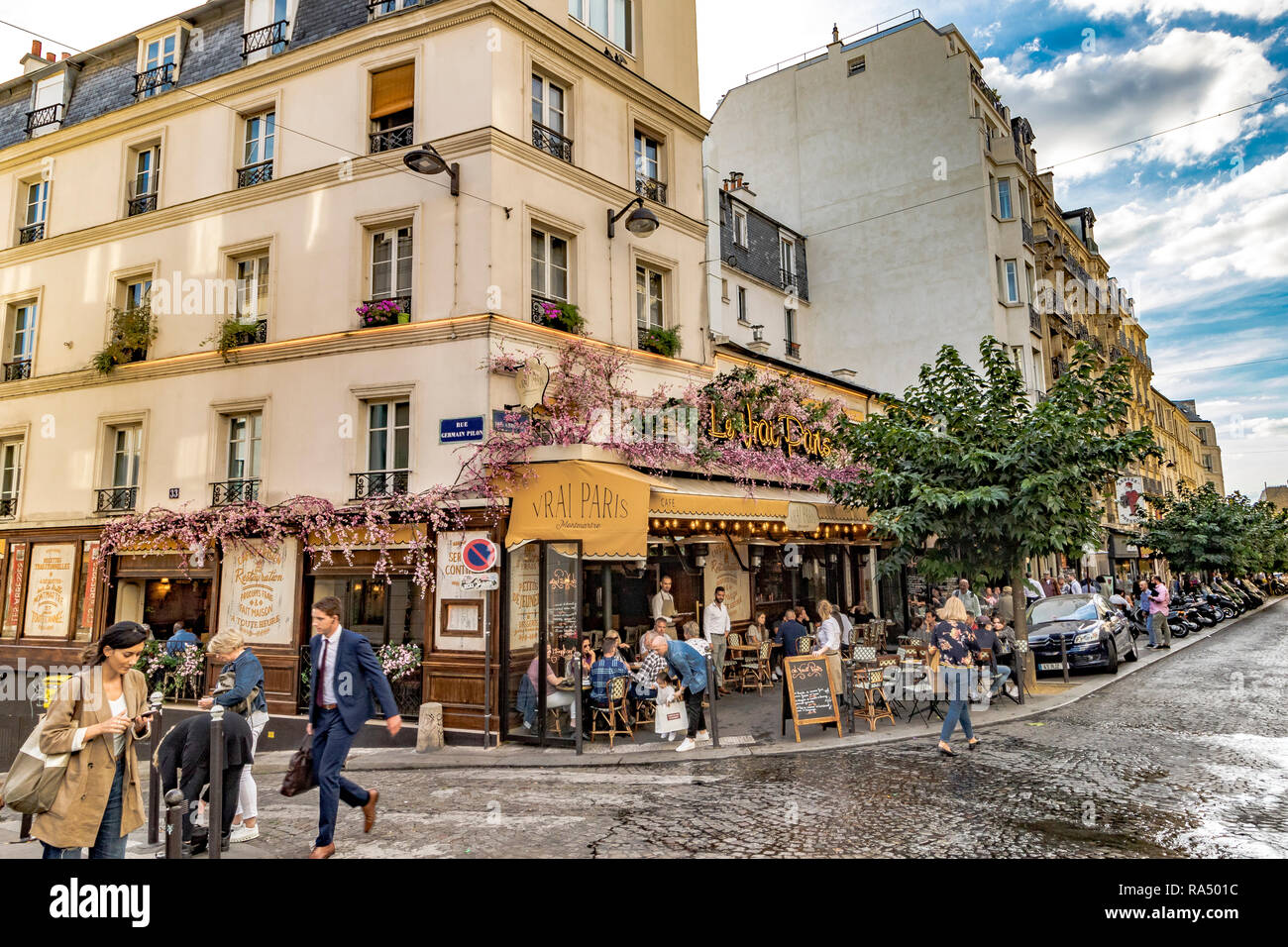 People eating lunch outside on the pavement tables at Le Vrai restaurant and cafe, Rue des Abbesses,Paris Stock Photo