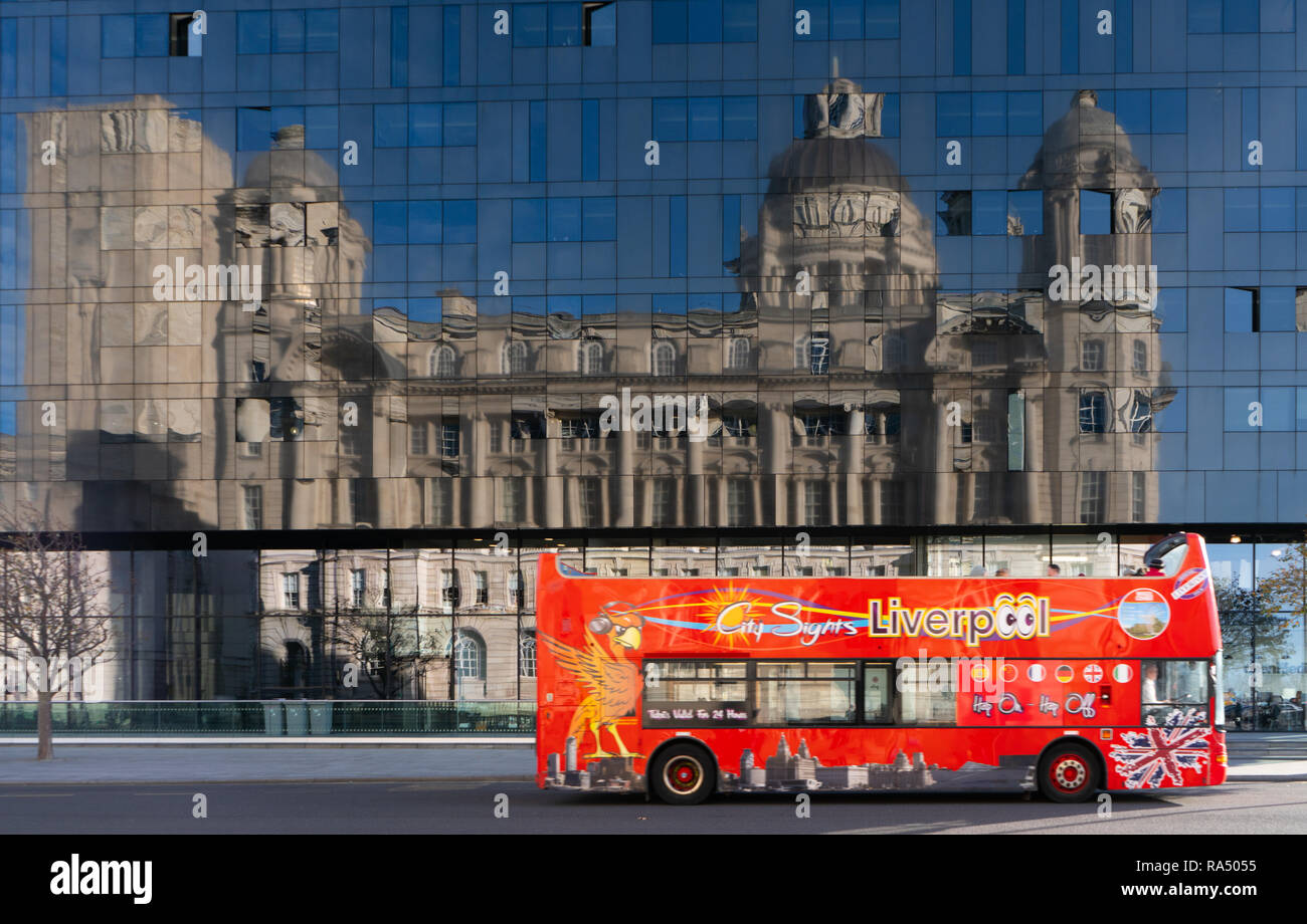 Tourist buses going past Mann Island Building, With Dock Board Building reflecting in the Mann Island Building, Liverpool. Taken in November 2018. Stock Photo