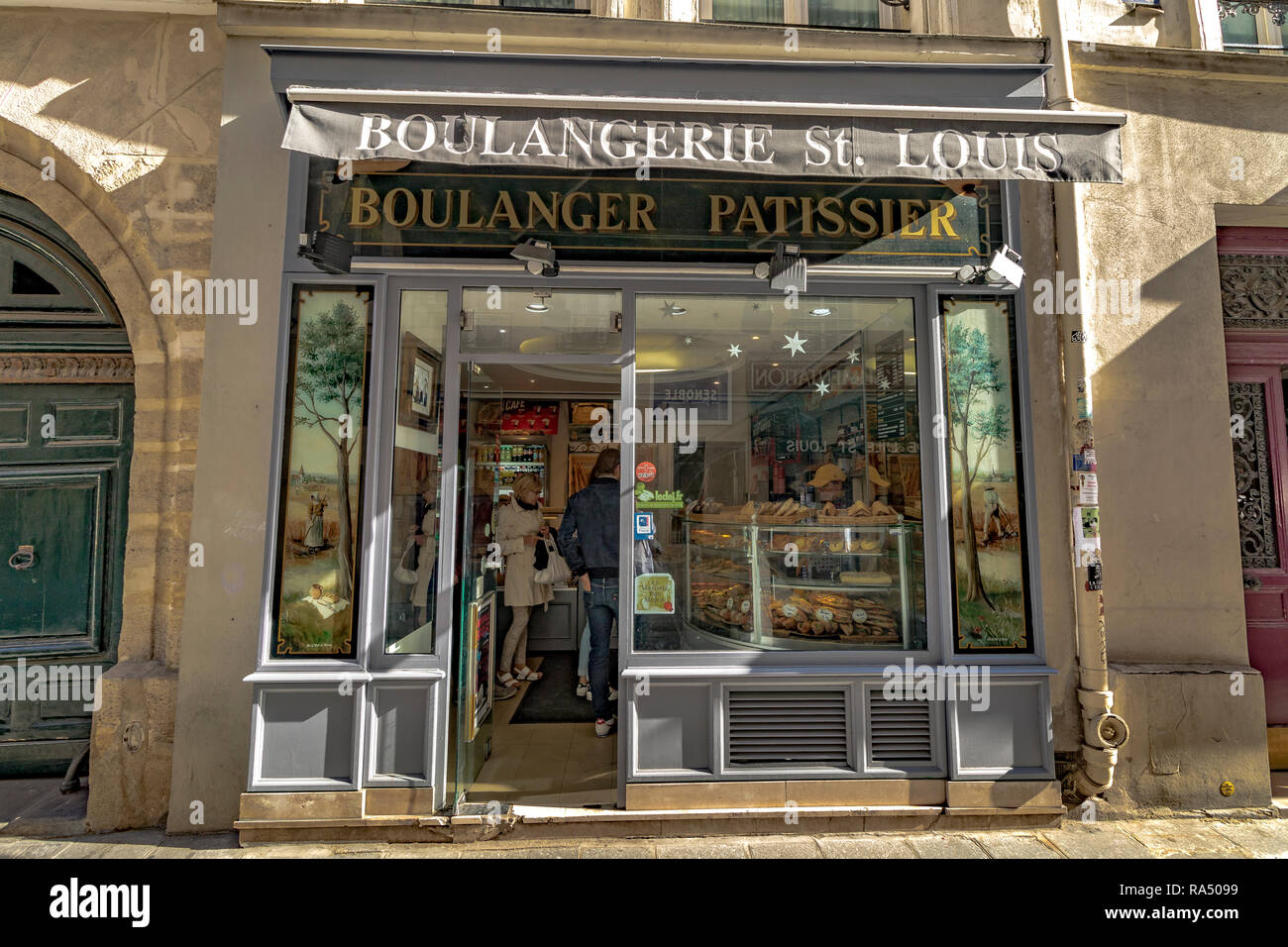 People buying bread in Boulangerie St Louis ,a bakery and pattissier  on Rue Saint-Louis en l'Île ,Paris,France Stock Photo