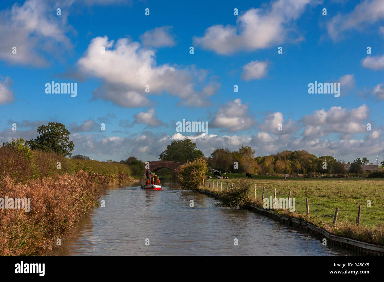 Narrowboat approaching Bridge 75 on the North Oxford Canal, Warwickshire, England, UK on a sunny Autumn day Stock Photo