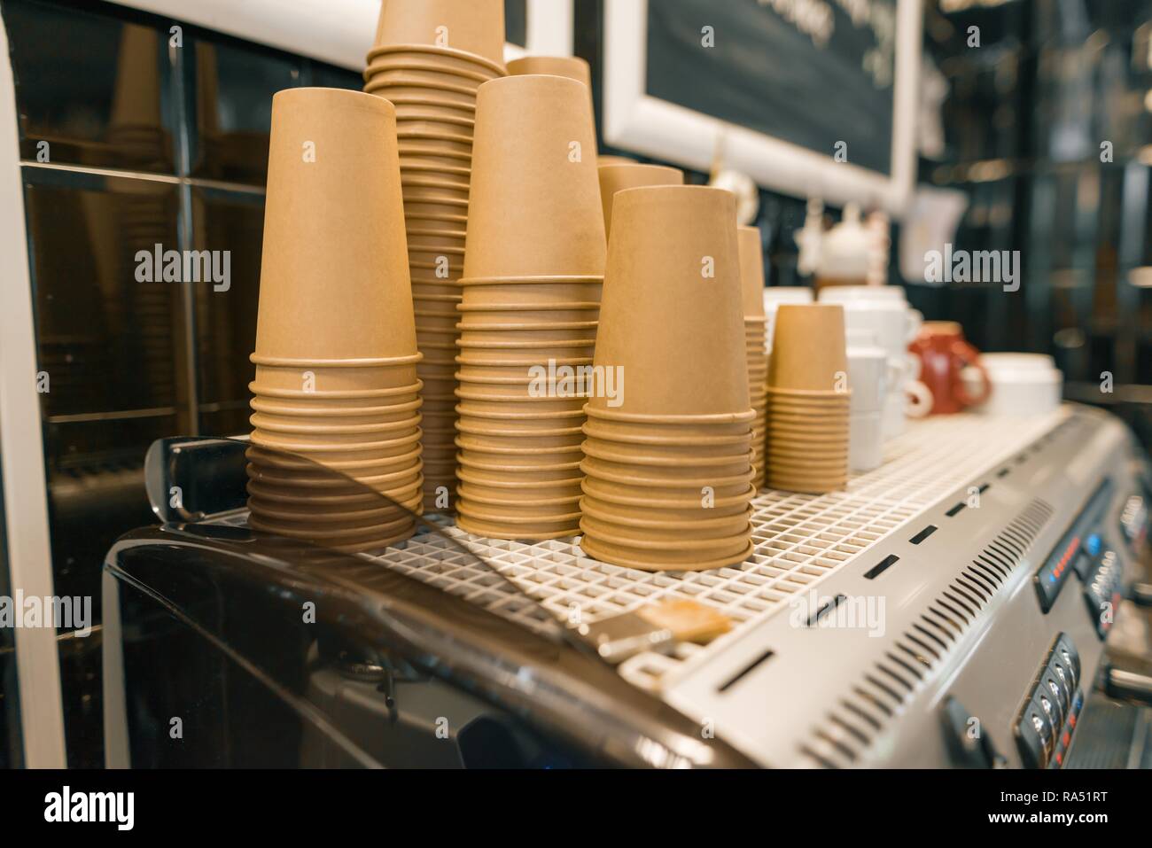 Brown kraft paper coffee cups closeup on coffee machine in coffee shop