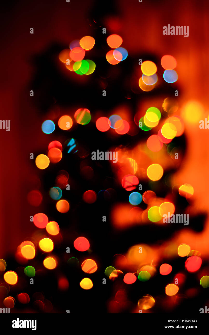 a bokeh of blue, green and yellow in the background, a new Christmas tree is blurred 2018 Stock Photo