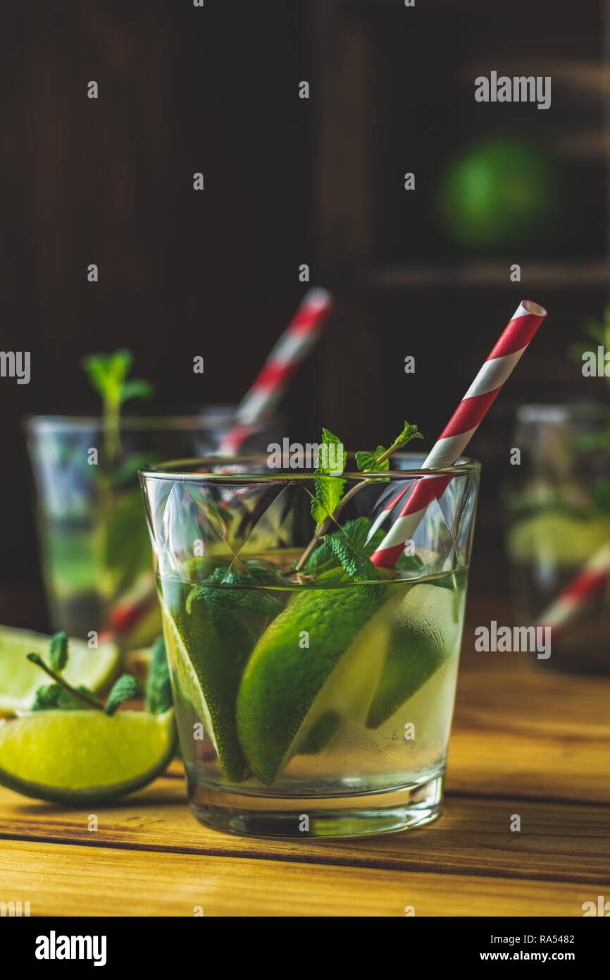 Fresh alcoholic cocktail with lime, ice and mint, mojito cocktail in a bur on a rustic table, selective focus, shallow depth of the field. Stock Photo