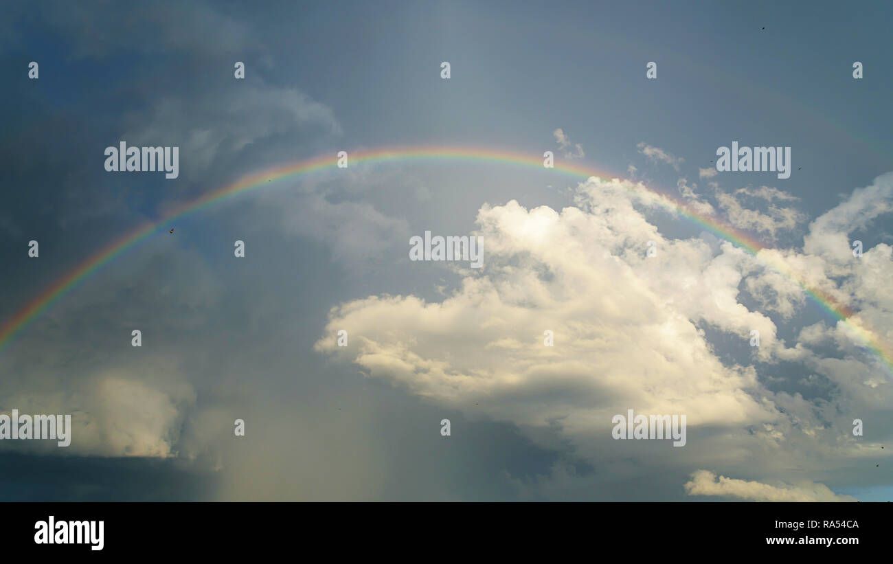 Rainbow clouds rain sun blue sky hi-res stock photography and images ...