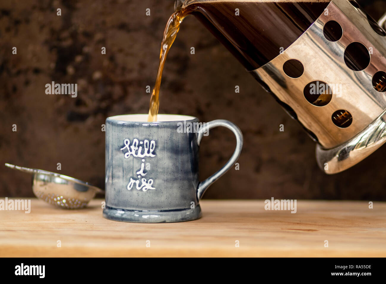 Pouring black coffee into mug Stock Photo