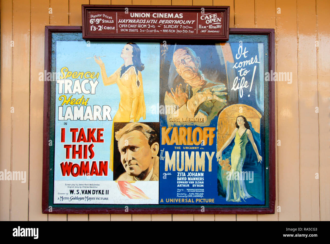 Old advertising panel for films at local cinema, on wall at railway station, England Stock Photo