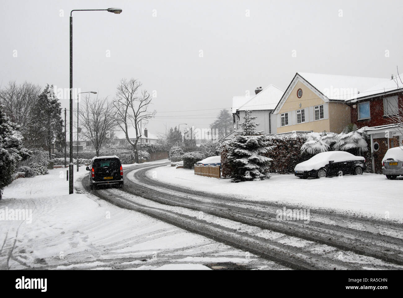 Falling snow on bend in local suburban road, England Stock Photo Alamy