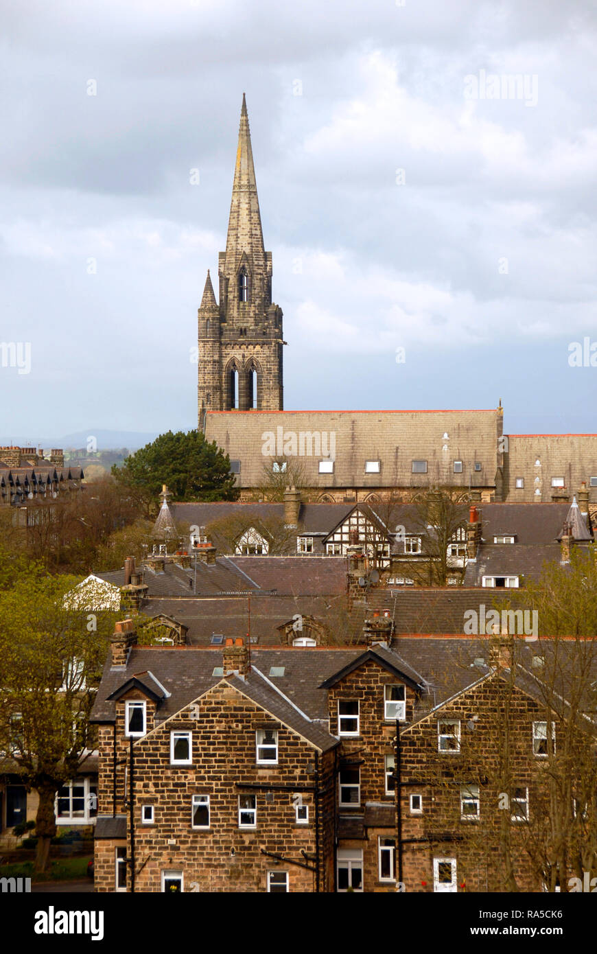 Church with steeple, seen towering over residential property,  Harrogate, Yorkshire, England Stock Photo